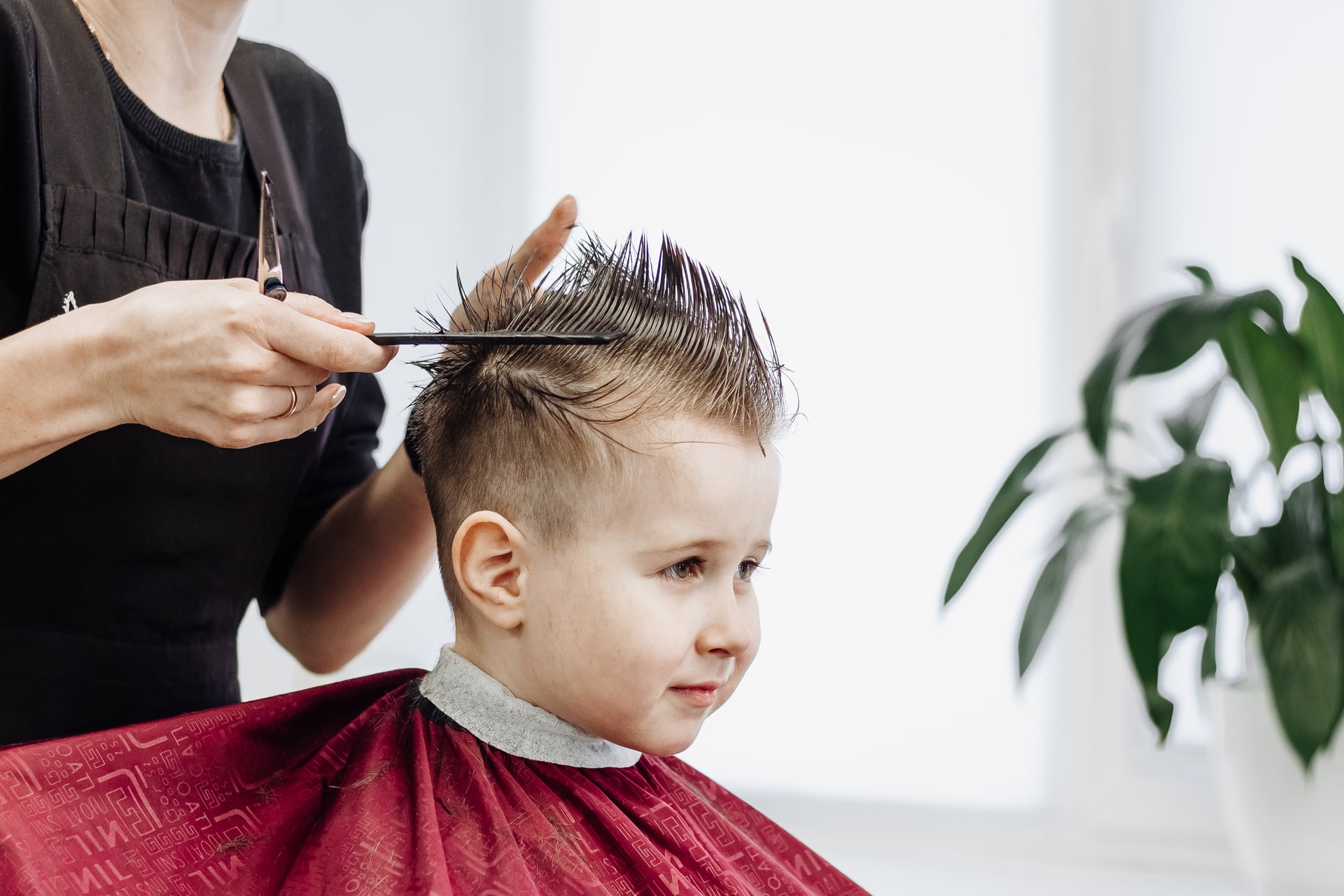 Frisør som klipper håret til et barn